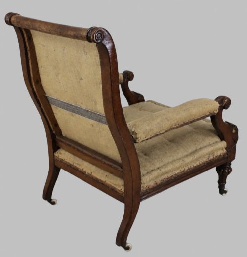fig 2. Side profile of a William IV carved oak armchair with upholstered seat, scrolled arms, turned front legs, and castors.