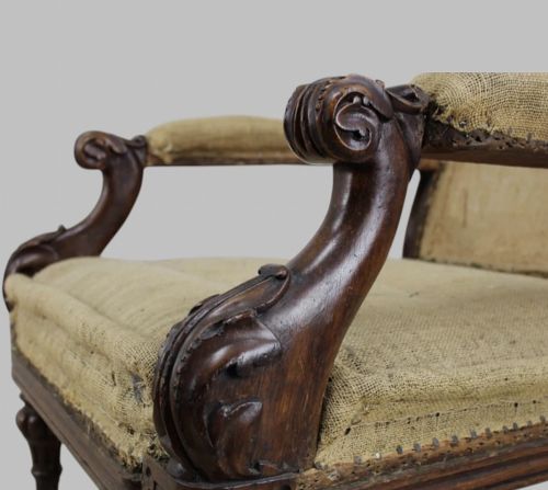 fig 3. Side profile of a William IV carved oak armchair with upholstered seat, scrolled arms, turned front legs, and castors.