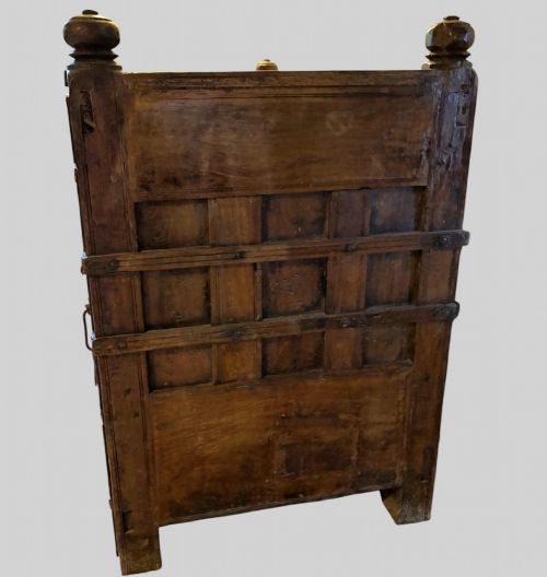 fig 4. A carved dark hardwood storage bench with a hinged lid seat, geometric panelled backrest, corner post finials, and iron fittings.