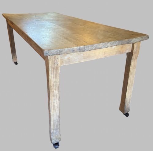 fig 2. A 19th-century rectangular elm farmhouse table featuring a multi-plank top, straight aprons, four square tapering legs, and small metal castors.