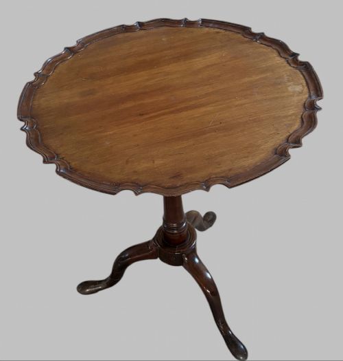 fig 1. A dark mahogany tripod table featuring a circular pie-crust scalloped top, a turned central column with a birdcage block, and three cabriole legs ending in pad feet.