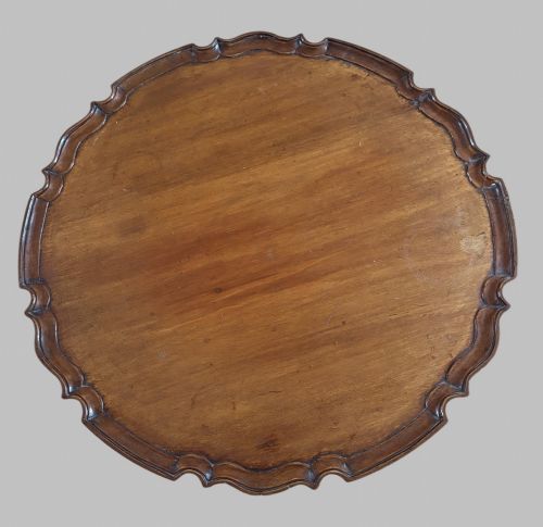 fig 2. A dark mahogany tripod table featuring a circular pie-crust scalloped top, a turned central column with a birdcage block, and three cabriole legs ending in pad feet.