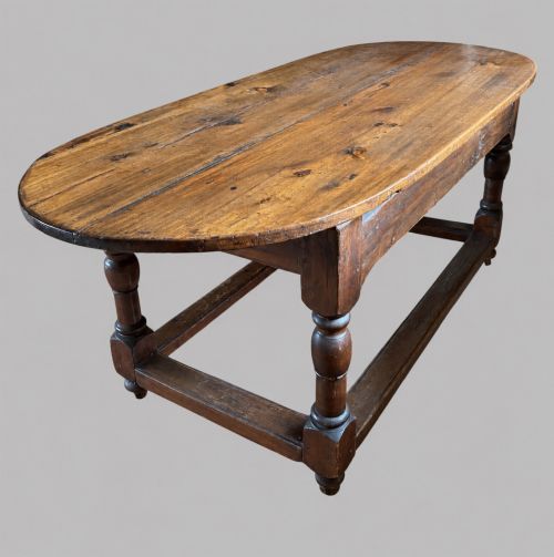 fig 1. An antique Swedish provincial pine farmhouse table featuring an oval plank top, frieze with drawer moulding, turned baluster legs, and a low rectangular box stretcher.