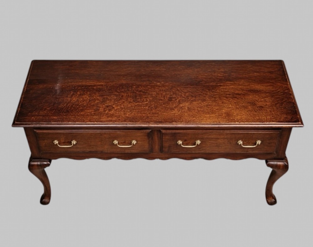 A late nineteenth-century oak dresser base featuring two drawers with brass handles, a scalloped lower apron, and cabriole legs. View III