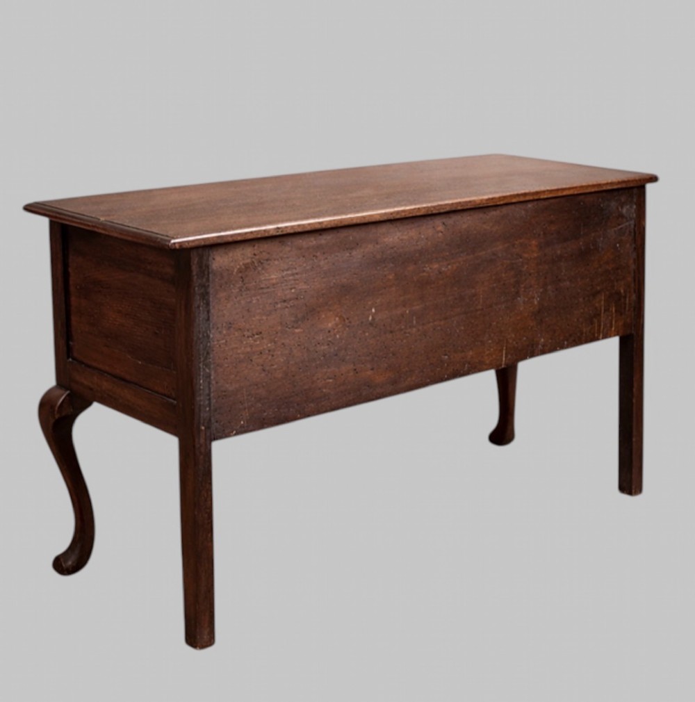 A late nineteenth-century oak dresser base featuring two drawers with brass handles, a scalloped lower apron, and cabriole legs. View IV