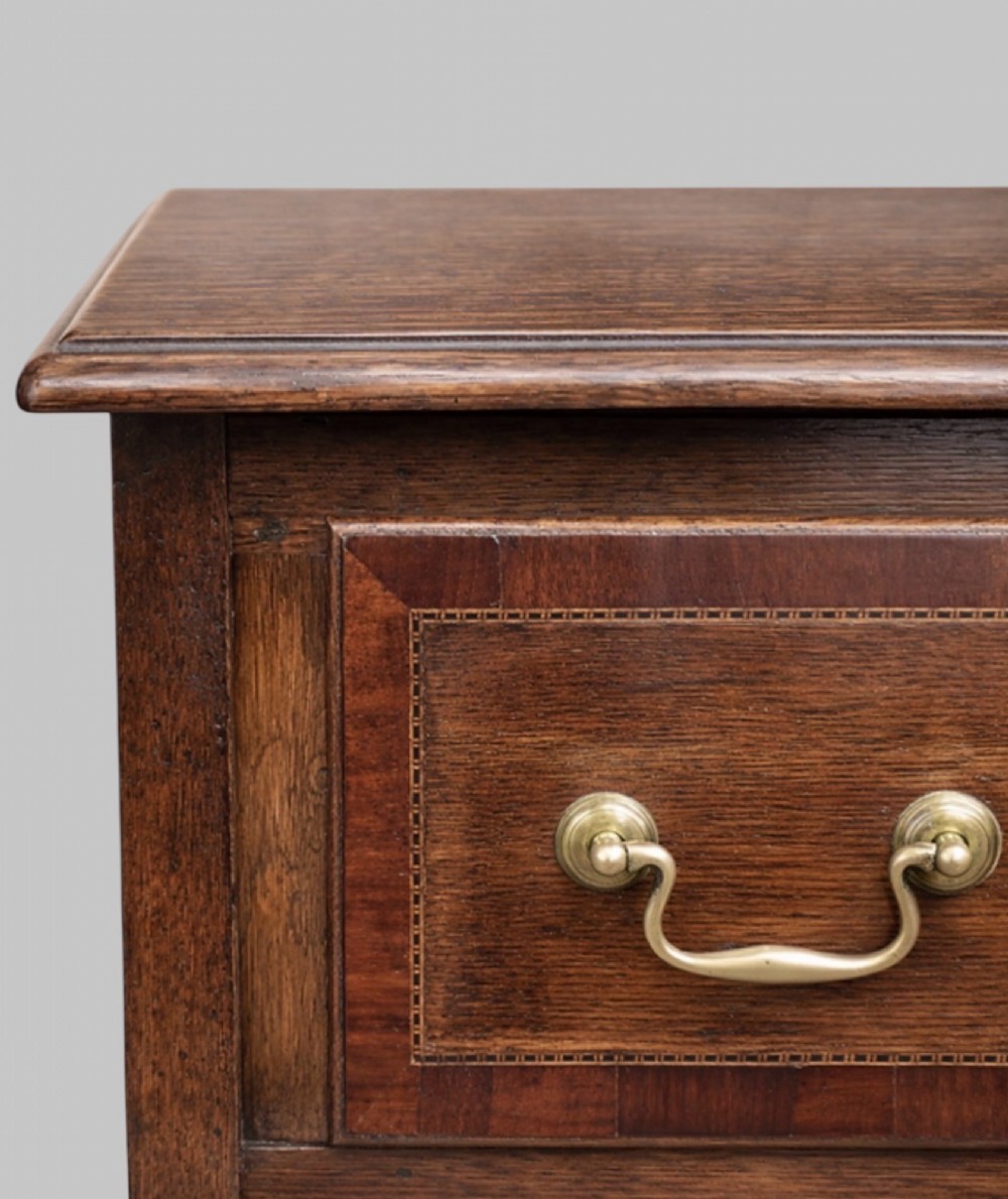 A late nineteenth-century oak dresser base featuring two drawers with brass handles, a scalloped lower apron, and cabriole legs. View VI