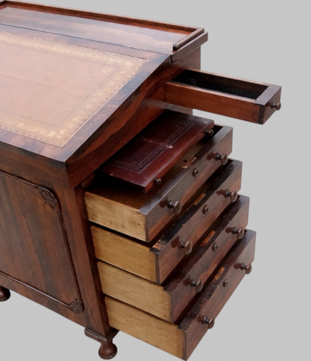 A Victorian rosewood Davenport desk featuring a slanted leather-tooled writing surface, side-mounted drawers, and turned feet. View VII