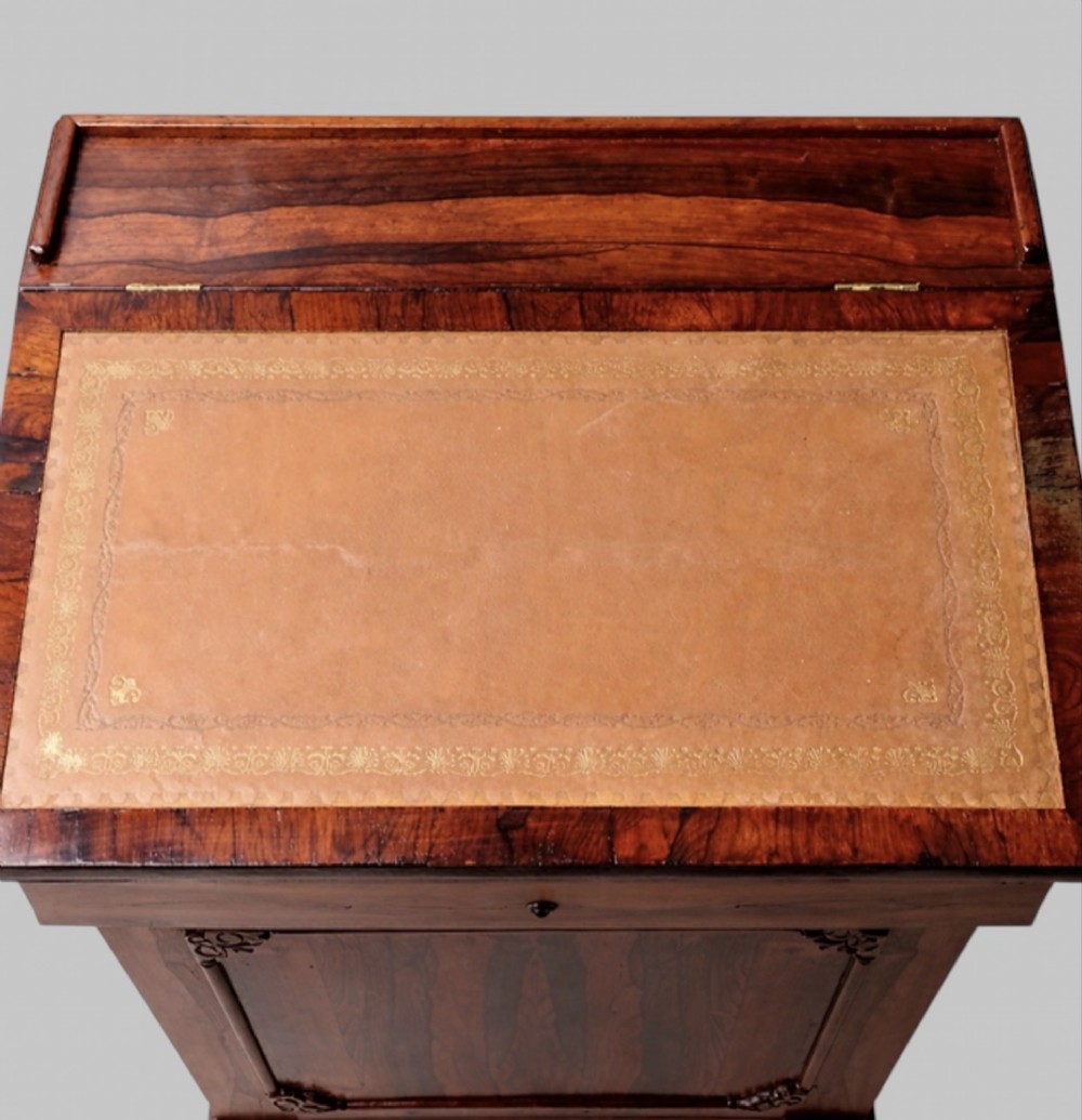 A Victorian rosewood Davenport desk featuring a slanted leather-tooled writing surface, side-mounted drawers, and turned feet. View VIII