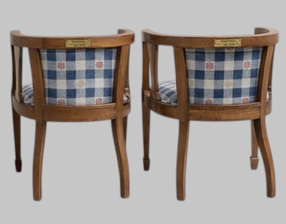A pair of Arts and Crafts oak tub armchairs with curved wooden frames and blue and white checked fabric upholstery. View II