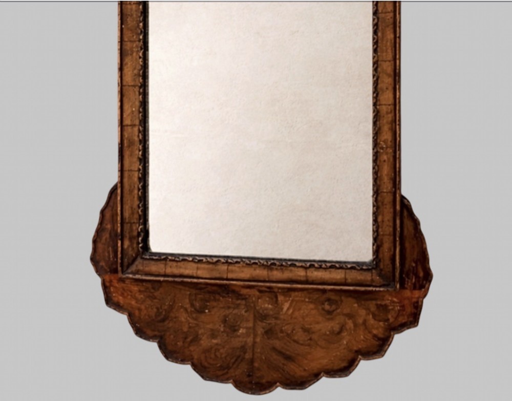 A late nineteenth-century carved walnut wall mirror featuring a scalloped outline, a central rectangular mirror frame, and an armorial crest detailing a knight helmet above crossed battleaxes. View III