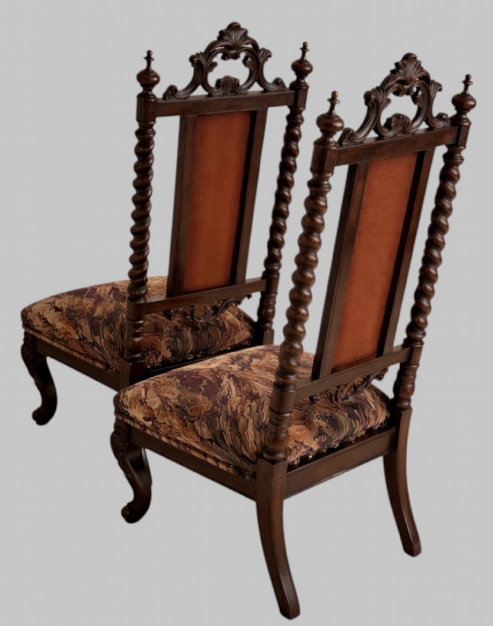 A pair of 19th-century carved walnut hall chairs featuring tall barley twist uprights, ornate cresting, cabriole front legs, and patterned upholstery. View II