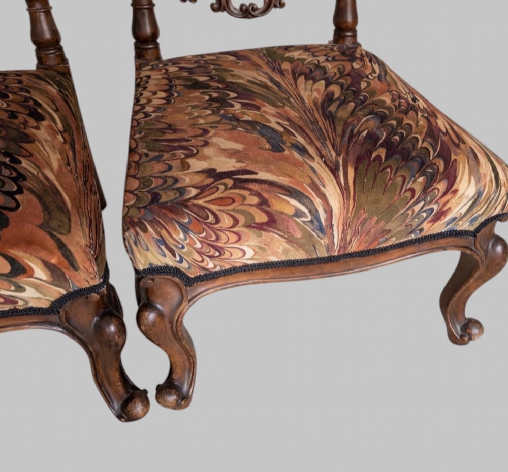 A pair of 19th-century carved walnut hall chairs featuring tall barley twist uprights, ornate cresting, cabriole front legs, and patterned upholstery. View IV