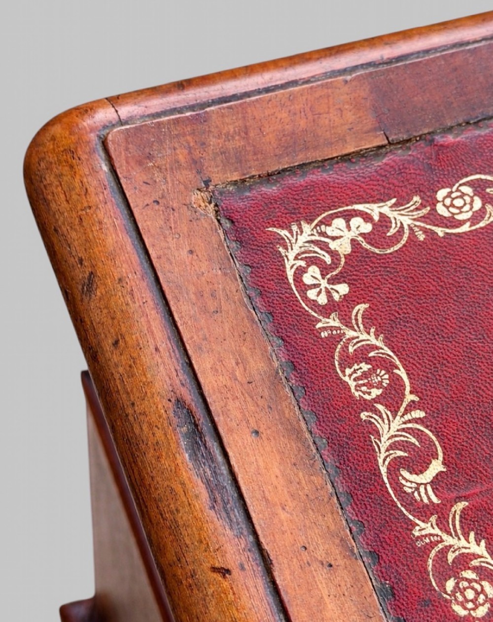 A late Victorian mahogany pedestal desk featuring an inset red leather writing surface, nine drawers with round brass pulls, and two plinth bases. View VII