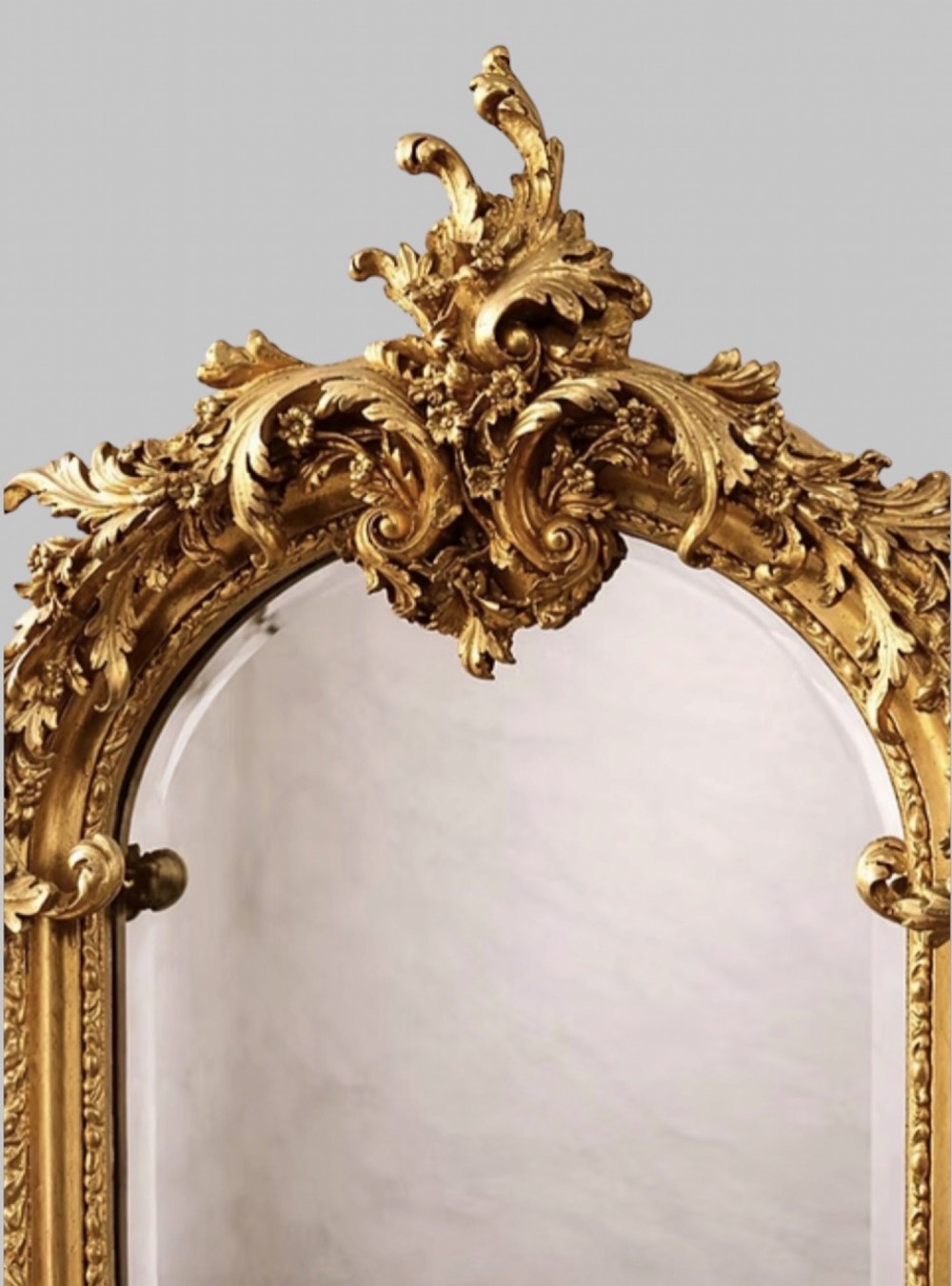 A pair of tall arched giltwood mirrors featuring detailed acanthus leaf cresting and moulded gold frames. View III
