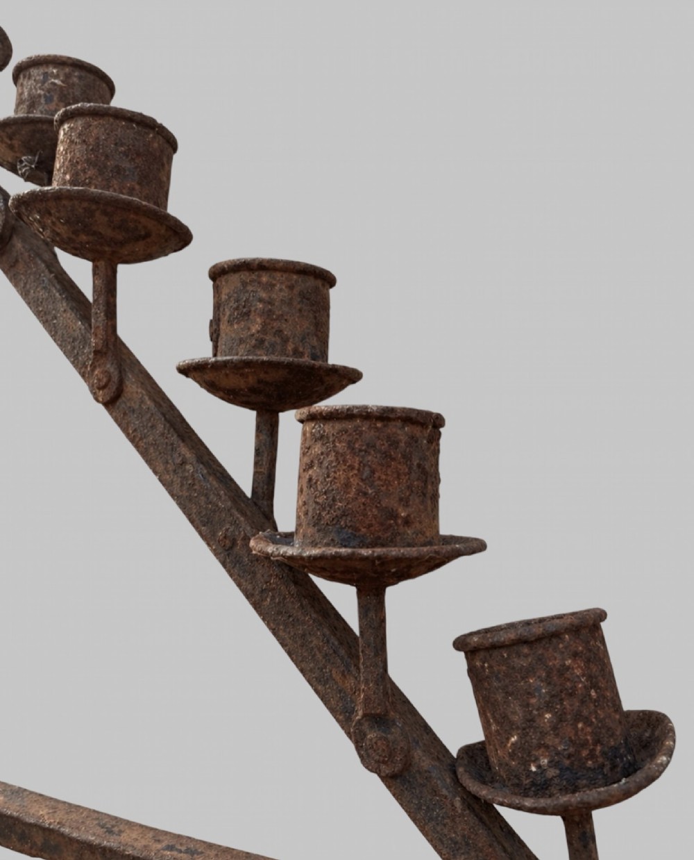 A tall dark wrought iron floor candelabrum featuring a triangular frame with fifteen candle sockets set upon a twisted central stem and tripod base. View IV