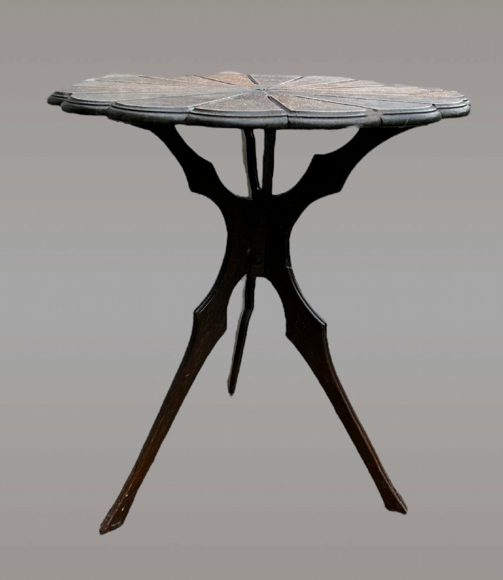 A seven-piece dark carved oak parlour suite comprising a central round table, five chairs, and one stool with radiating petal design tops and curved trestle legs. View III