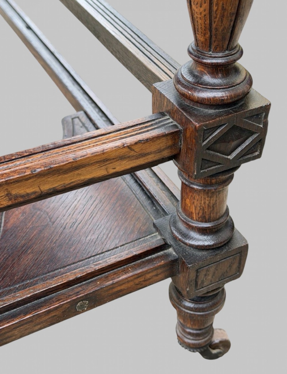 Victorian carved oak writing desk featuring a leather inset surface, two raised drawer cabinets on the top, two carved frieze drawers with brass drop handles, turned legs, and stretchers. View X