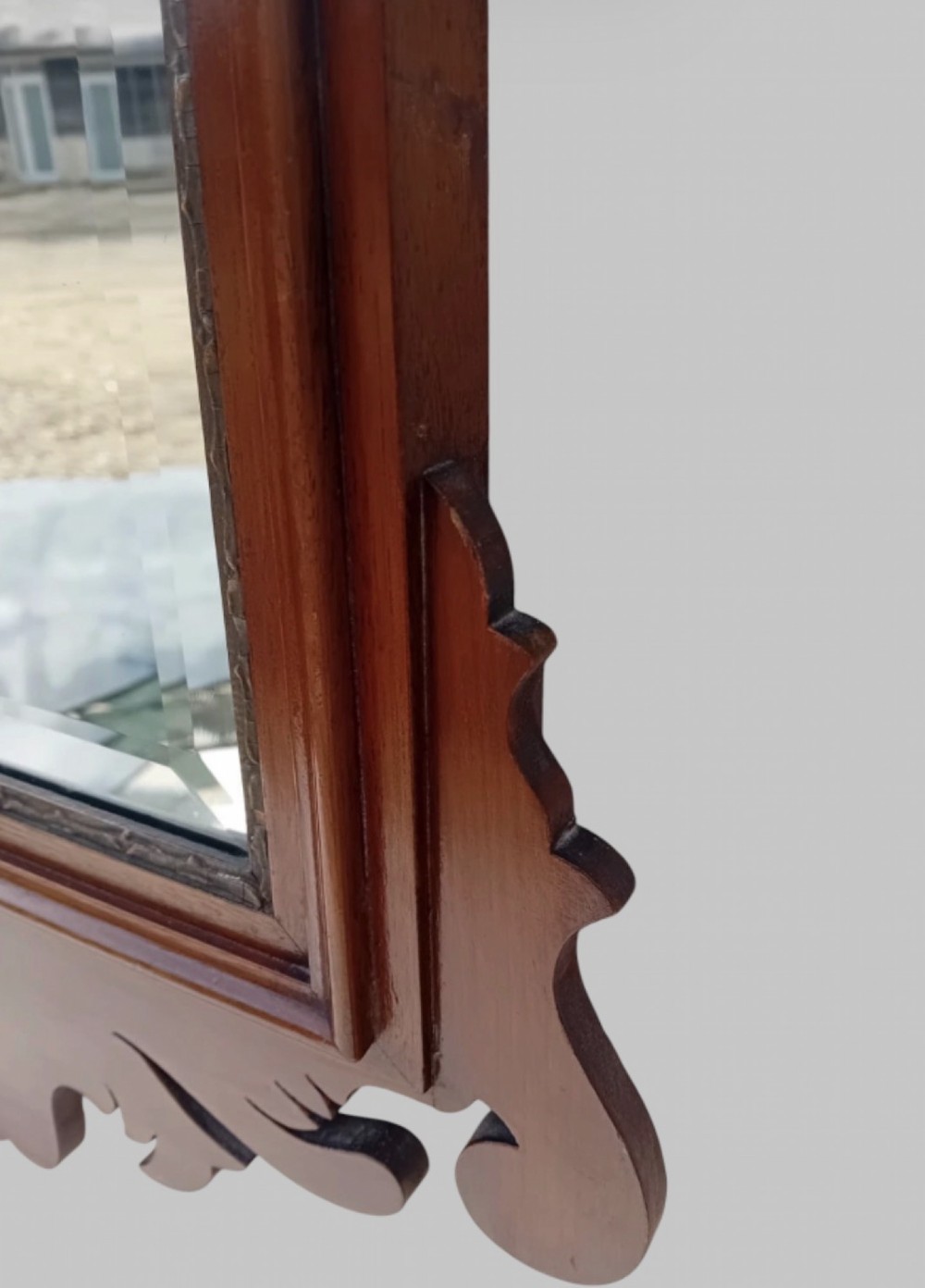 A tall Victorian Chippendale Revival mahogany wall mirror with a scrollwork fretcut frame, a crest depicting a bird, an oval shell inlay at the base, and bevelled glass. View III