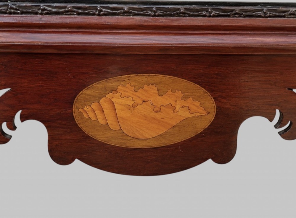 A tall Victorian Chippendale Revival mahogany wall mirror with a scrollwork fretcut frame, a crest depicting a bird, an oval shell inlay at the base, and bevelled glass. View V