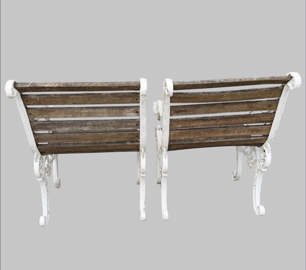 A pair of cast iron garden armchairs featuring white painted frames with lion mask armrest terminals and weathered timber slats. View II
