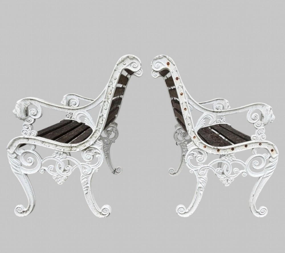 A pair of cast iron garden armchairs featuring white painted frames with lion mask armrest terminals and weathered timber slats. View III
