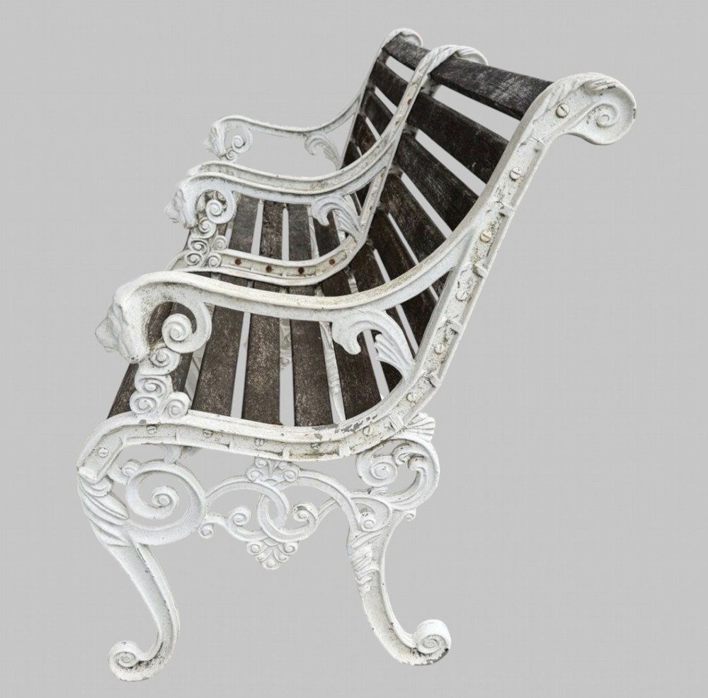 A pair of cast iron garden armchairs featuring white painted frames with lion mask armrest terminals and weathered timber slats. View IV