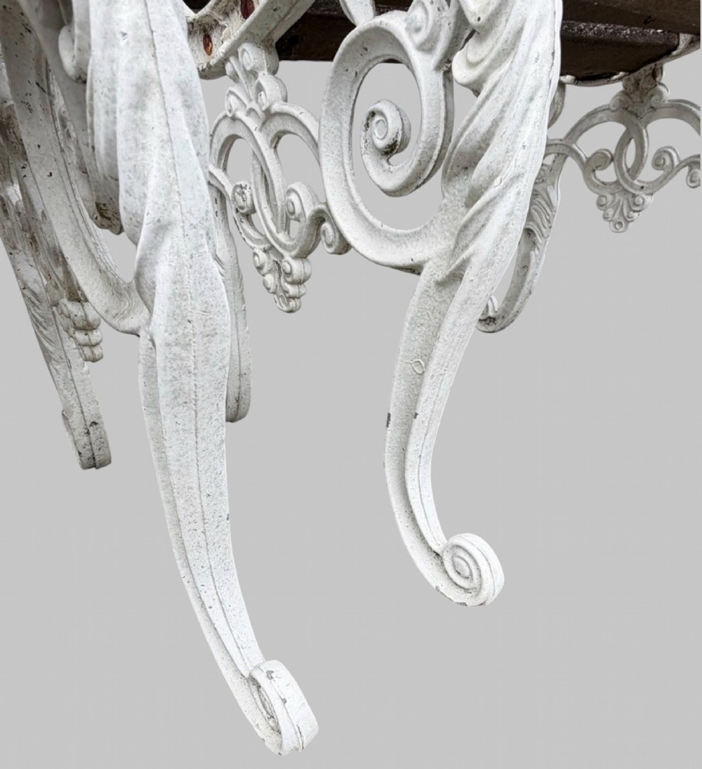 A pair of cast iron garden armchairs featuring white painted frames with lion mask armrest terminals and weathered timber slats. View V