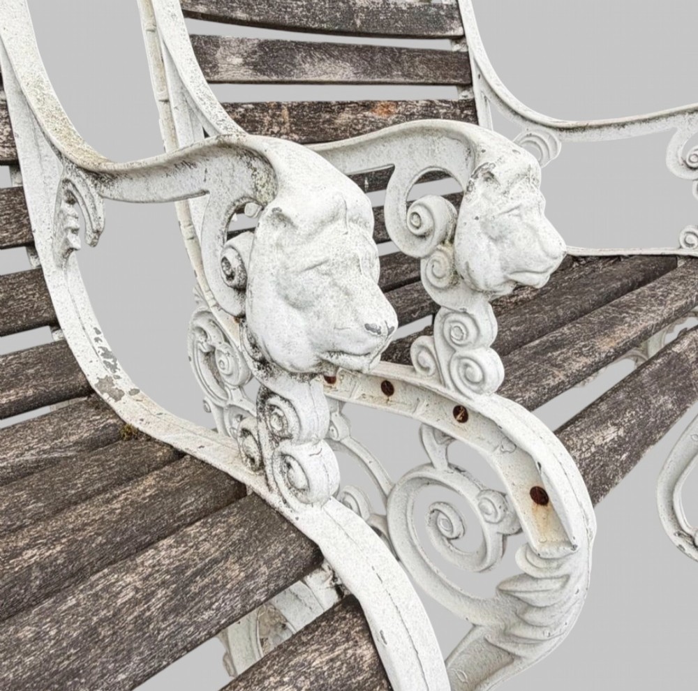 A pair of cast iron garden armchairs featuring white painted frames with lion mask armrest terminals and weathered timber slats. View VI