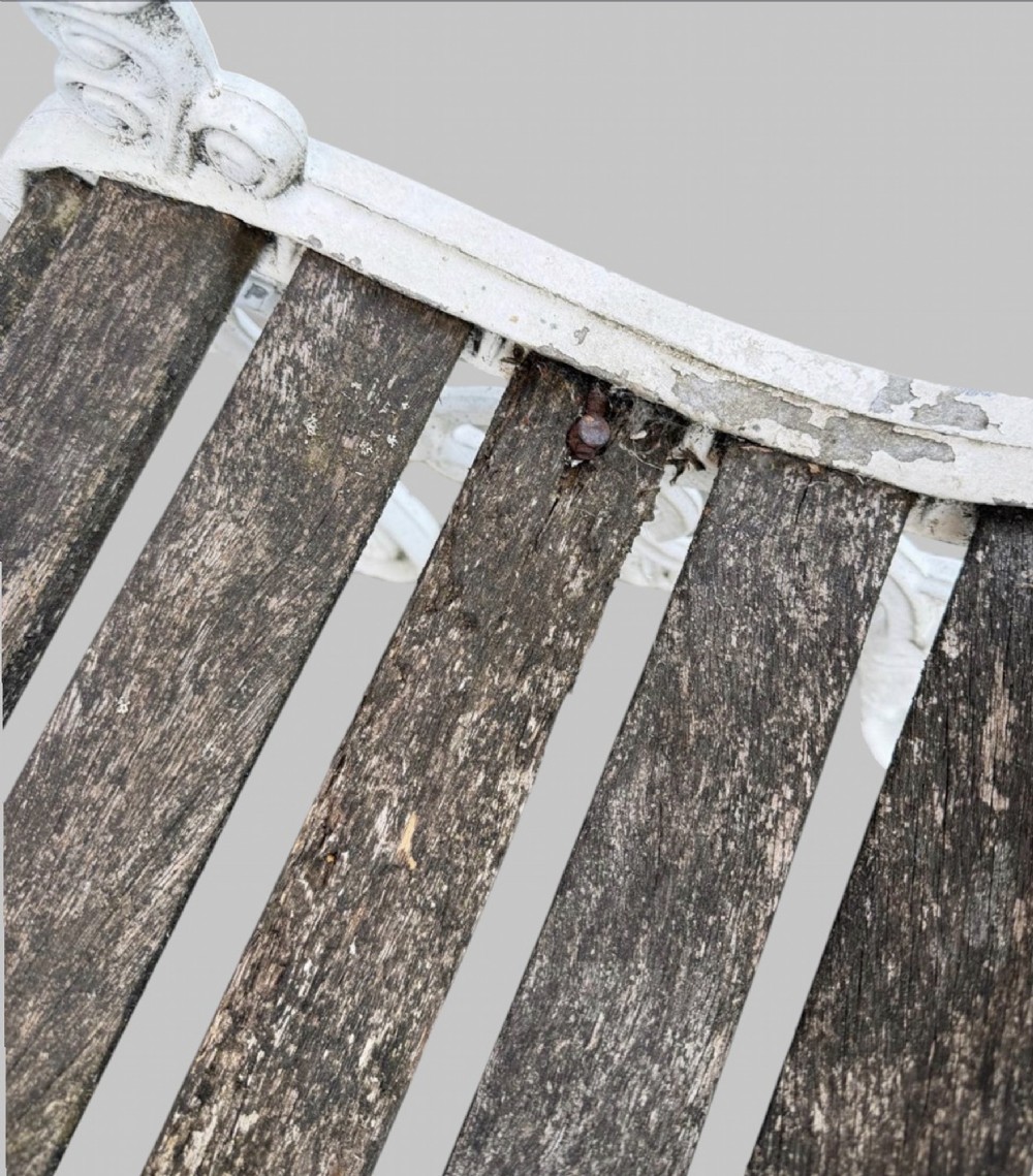 A pair of cast iron garden armchairs featuring white painted frames with lion mask armrest terminals and weathered timber slats. View VIII