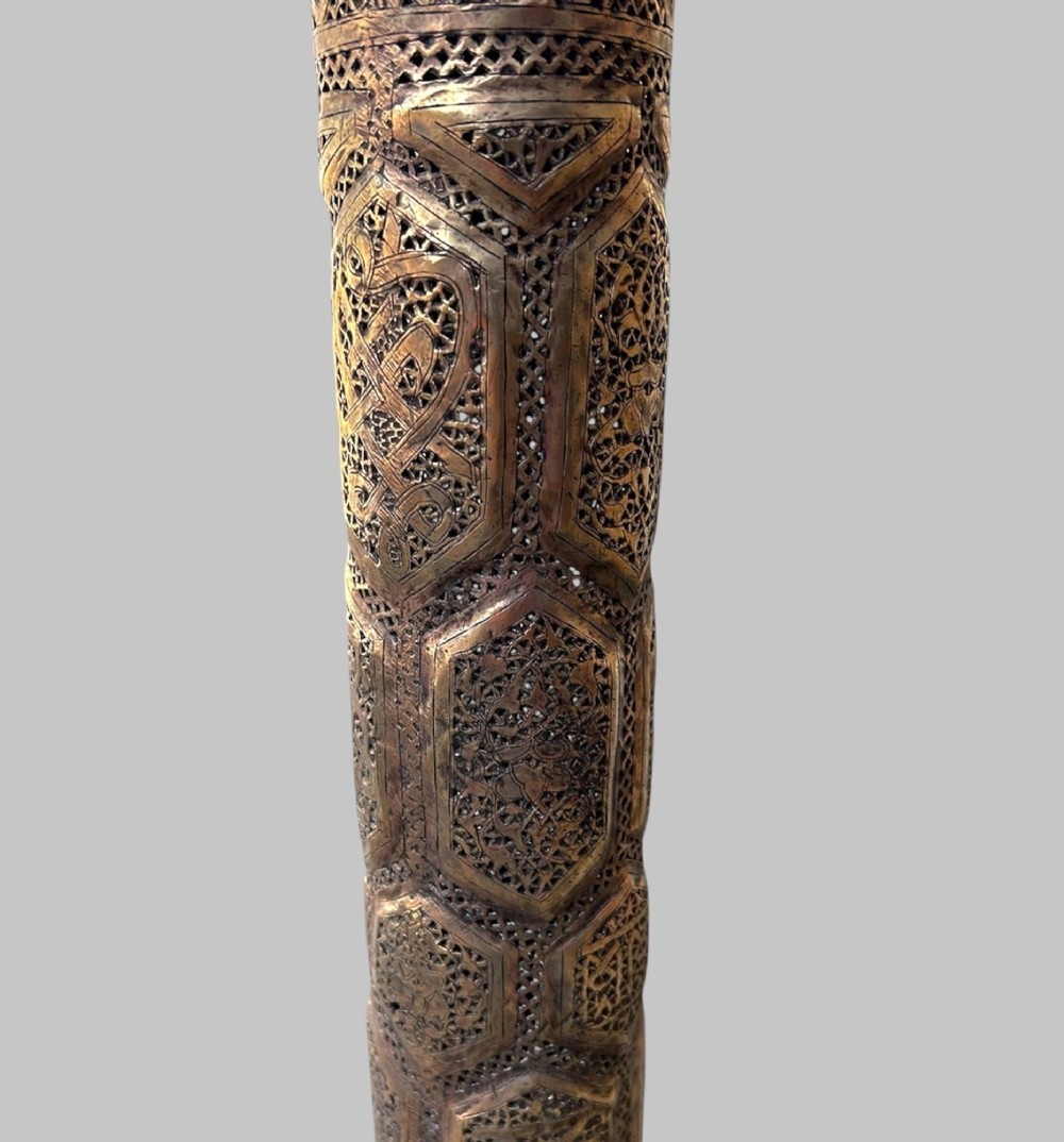 A tall Middle Eastern style brass floor lamp with an intricate pierced shade, decorative central column, and a wide flared base. View V