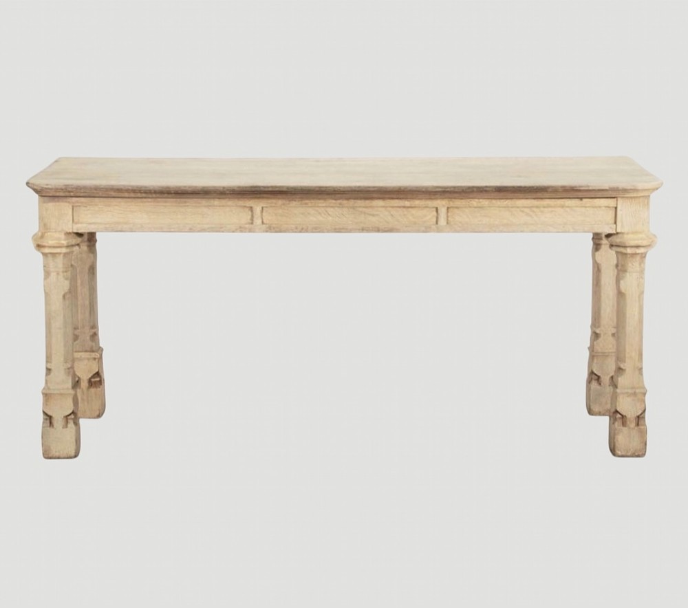 An early nineteenth-century bleached oak hall table featuring carved column supports and a plain rectangular top.