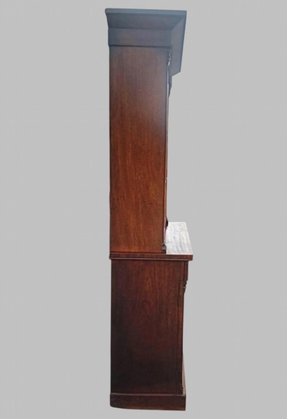 An early Victorian mahogany two-height library bookcase featuring upper glazed doors, flame mahogany lower panels, and carved pilasters. View III
