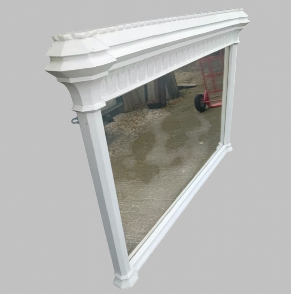 A large late Victorian rectangular overmantel mirror featuring a white painted wooden frame with a prominent corniced top and carved moulding. View III