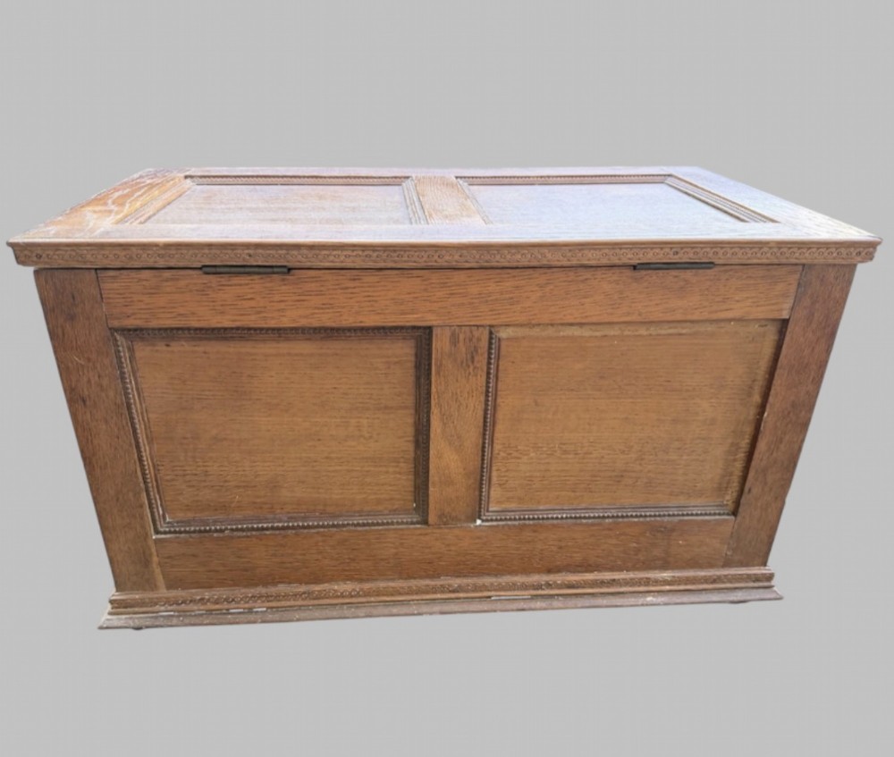 A solid oak Edwardian blanket chest featuring twin recessed front panels with carved beaded trim and a matching hinged lid. View V