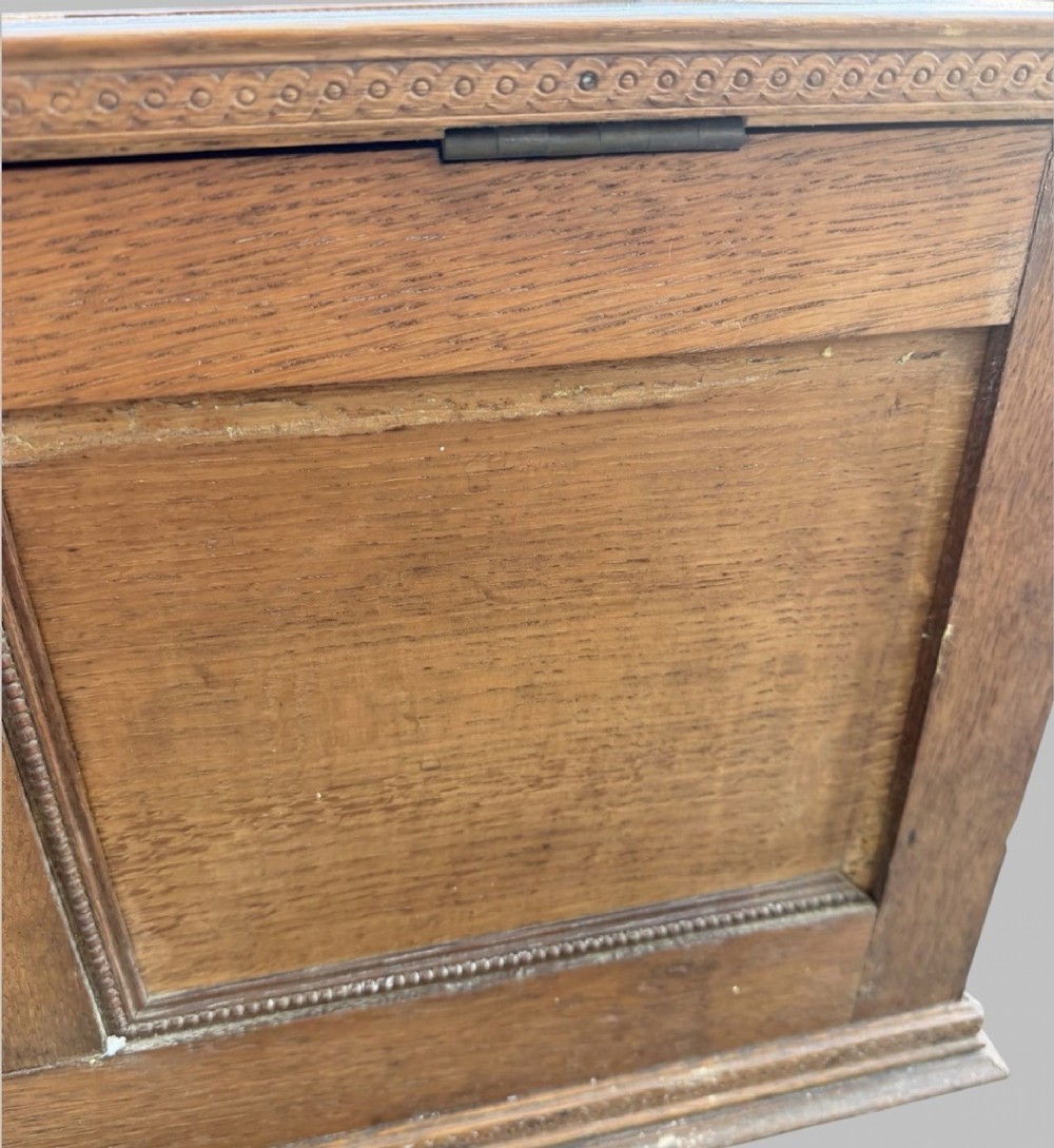 A solid oak Edwardian blanket chest featuring twin recessed front panels with carved beaded trim and a matching hinged lid. View VII