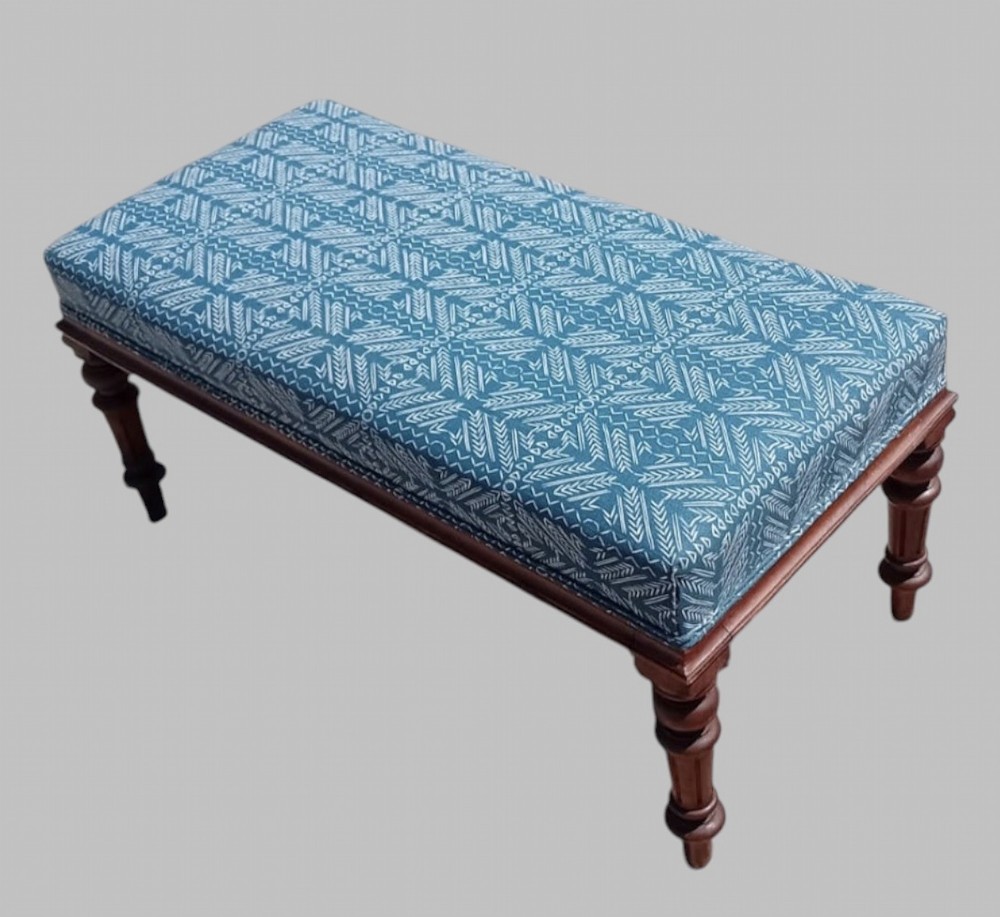 A rectangular late Victorian walnut window seat with turned wooden legs and a blue patterned upholstered cushion. View II