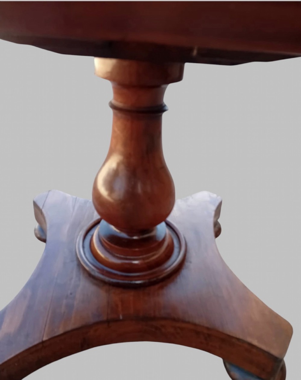 An upholstered William IV mahogany sewing box stool with red and cream striped fabric, mounted on a turned central pedestal and a concave platform base with bun feet. View IV