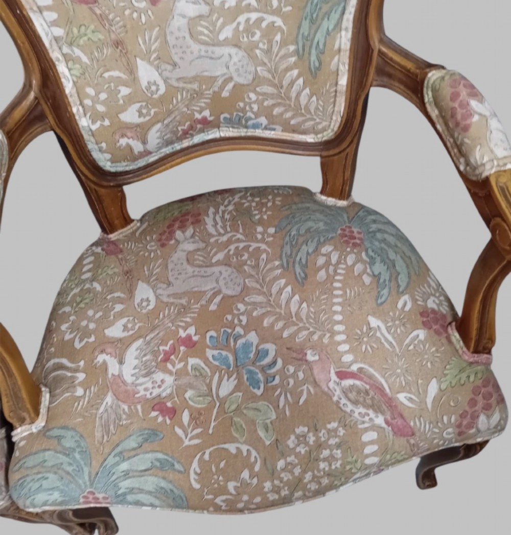 A pair of Neo-Rococo open armchairs featuring carved wooden frames, cabriole legs, and botanical tapestry upholstery. View V
