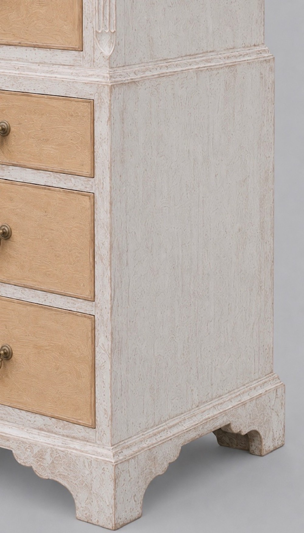 A George III chest on chest featuring a painted off-white frame, light tan drawer fronts, brass drop handles, and bracket feet. View V
