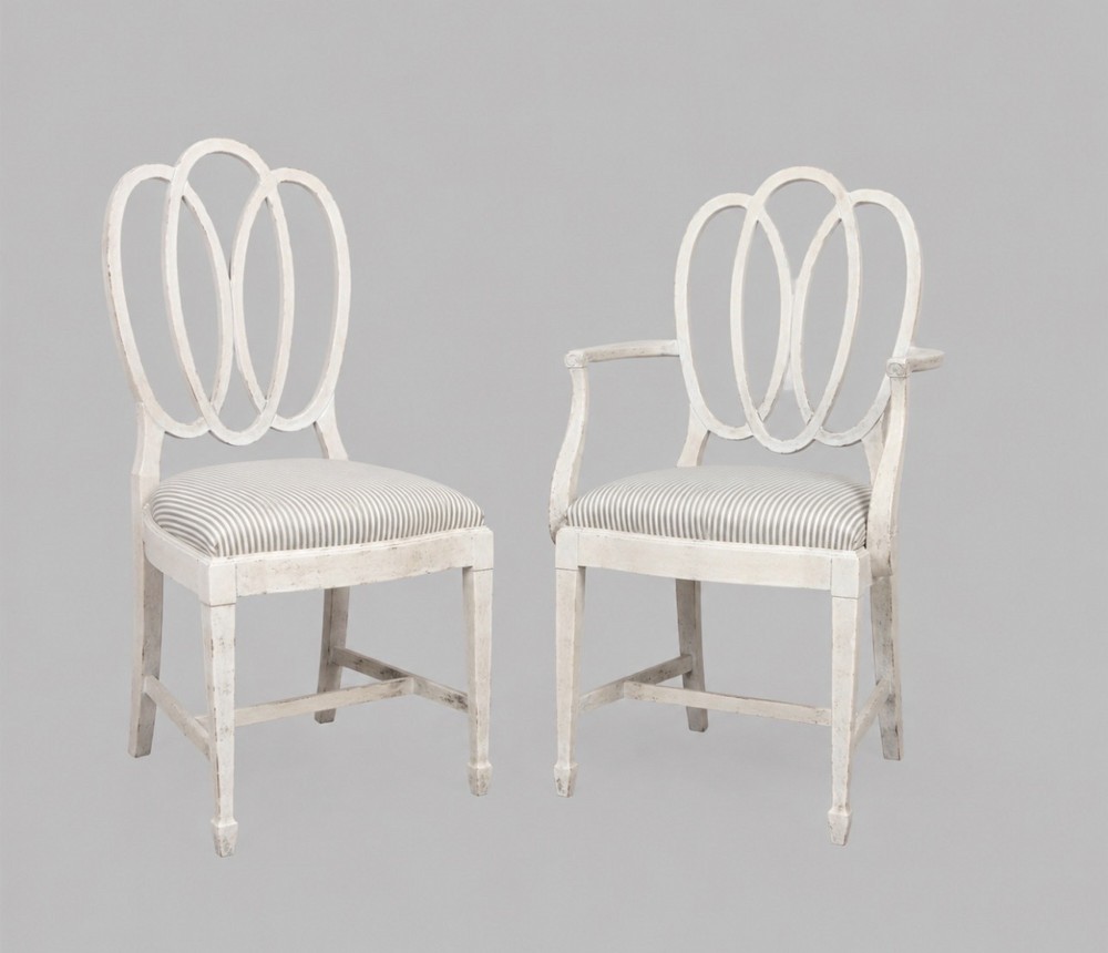 A set of eight off-white painted dining chairs featuring interlocking oval backrests, striped upholstered seats, including two carver armchairs and six side chairs. View II