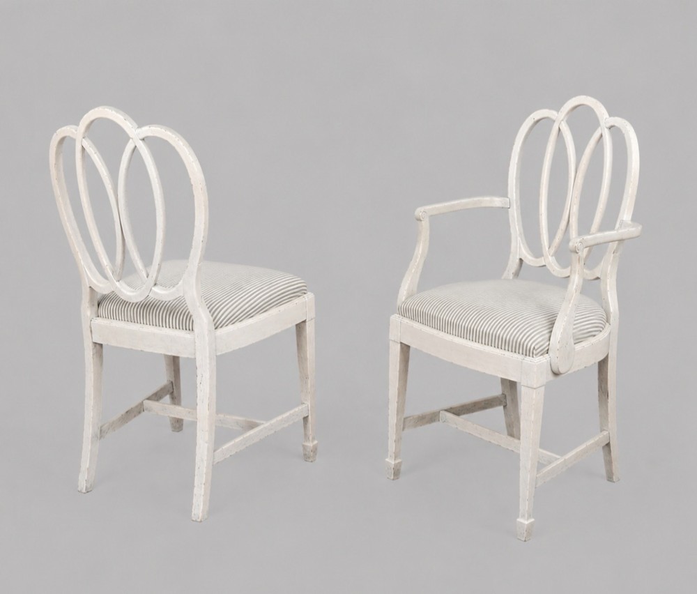 A set of eight off-white painted dining chairs featuring interlocking oval backrests, striped upholstered seats, including two carver armchairs and six side chairs. View III