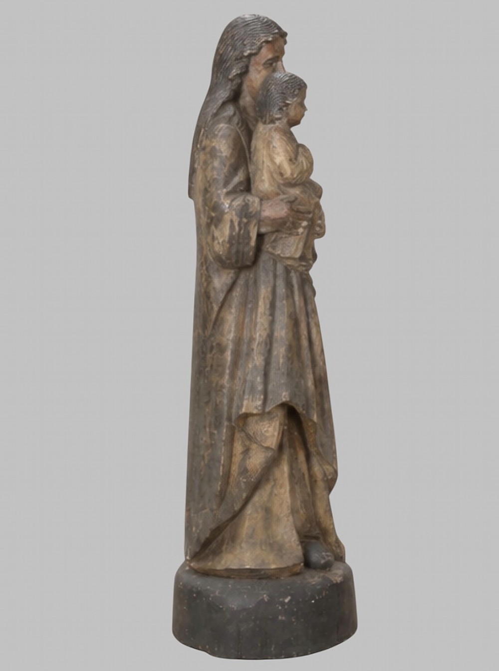 A carved wooden statue depicting the Virgin Mary holding the Infant Jesus on an integrated round base. View II