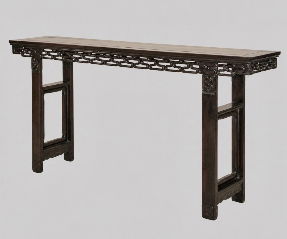 A late 19th-century Chinese dark hardwood altar table with an openwork geometric carved apron and recessed leg stretchers.