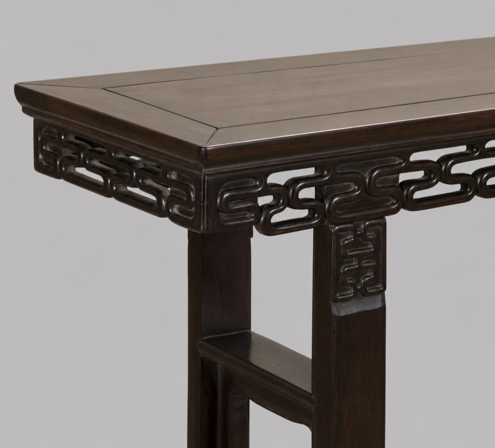 A late 19th-century Chinese dark hardwood altar table with an openwork geometric carved apron and recessed leg stretchers. View II