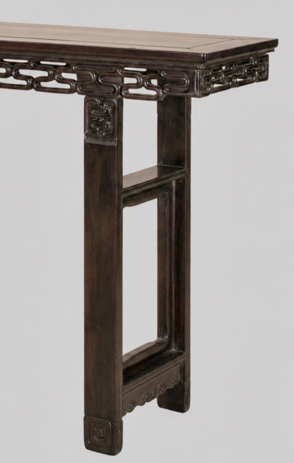 A late 19th-century Chinese dark hardwood altar table with an openwork geometric carved apron and recessed leg stretchers. View III