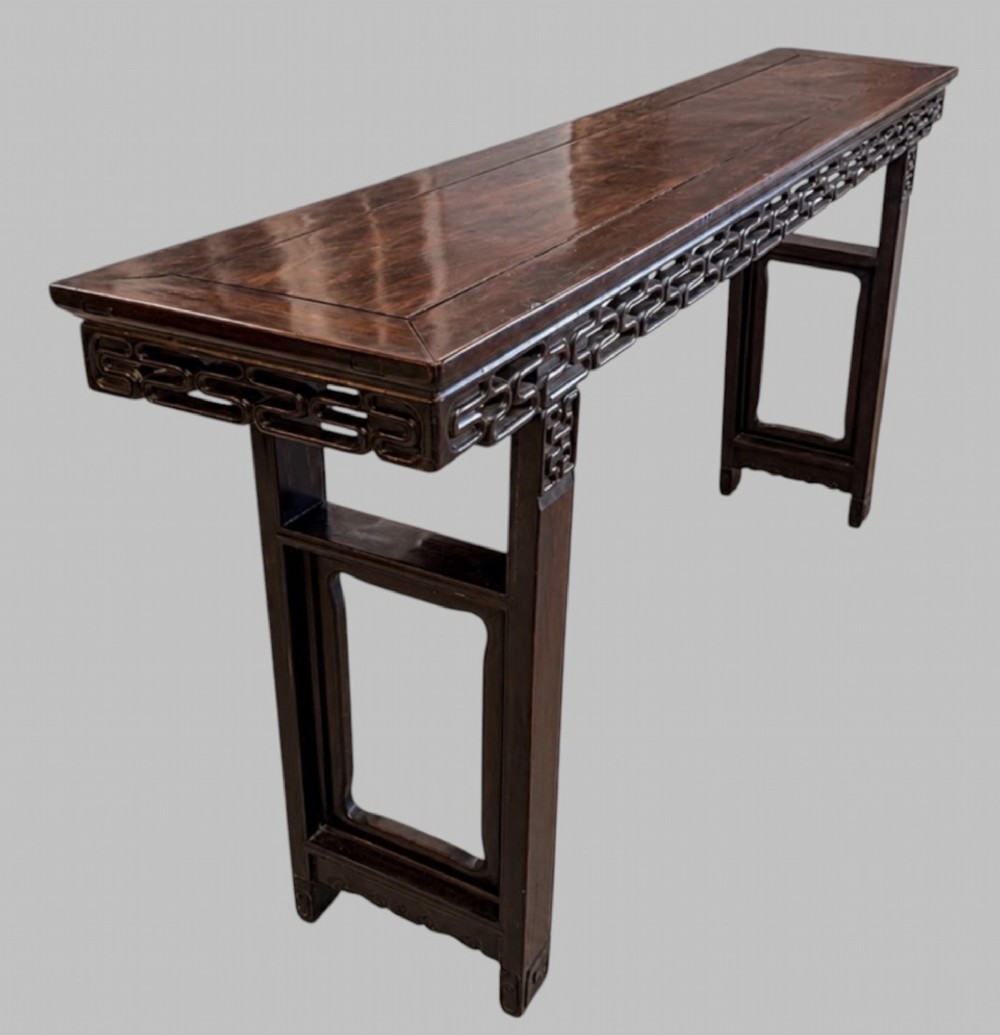 A late 19th-century Chinese dark hardwood altar table with an openwork geometric carved apron and recessed leg stretchers. View VII
