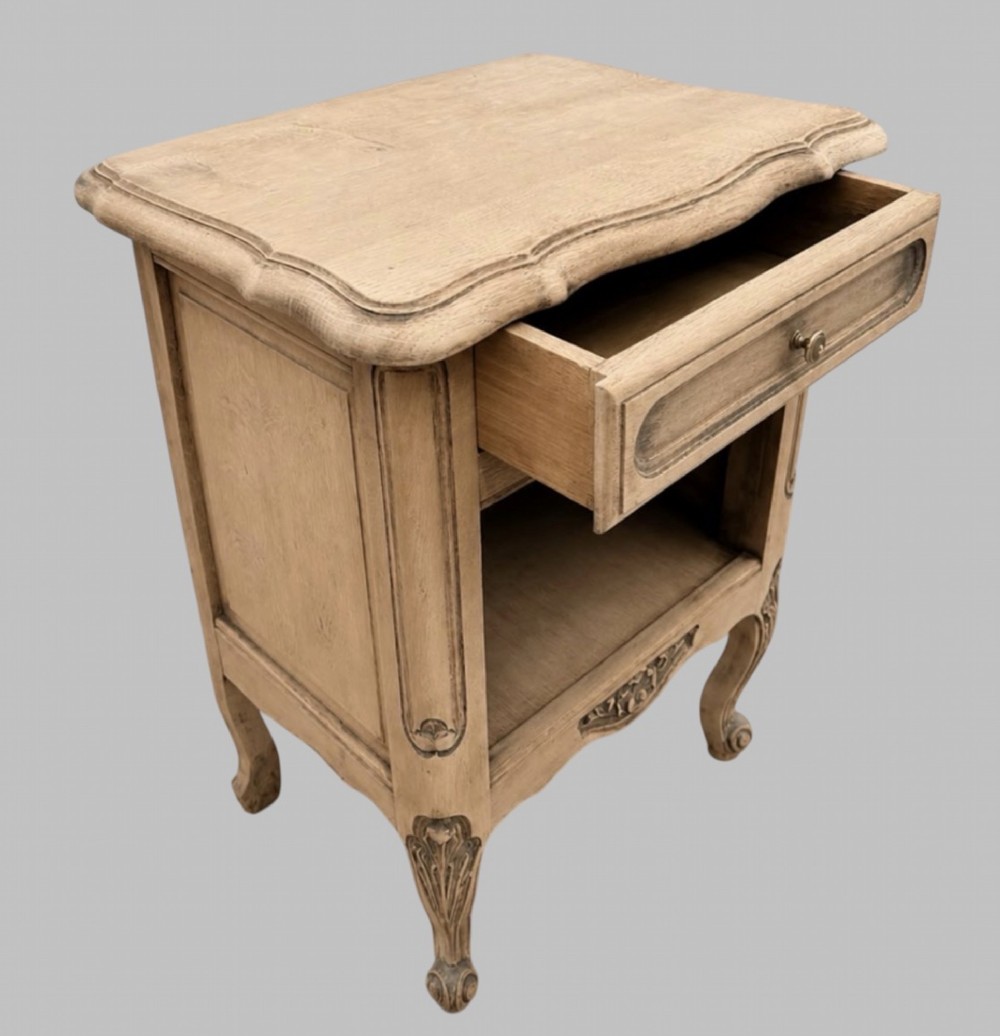 A pair of antique bleached oak bedside tables featuring carved cabriole legs, open storage shelves, and single top drawers with brass knobs. View VII