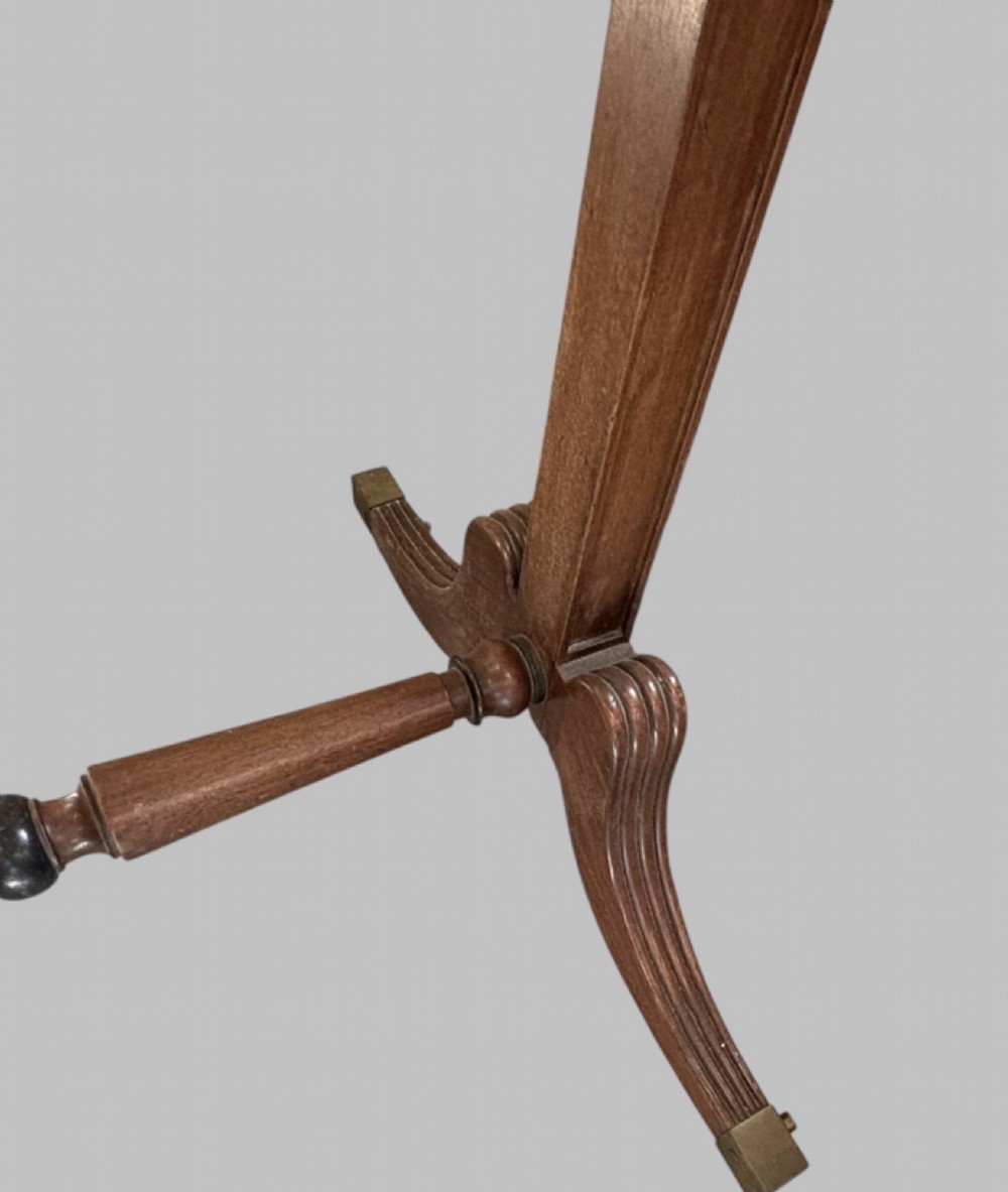 A nineteenth-century flame mahogany cheval mirror featuring turned side uprights, top finials, reeded splayed legs, and brass castors. View II