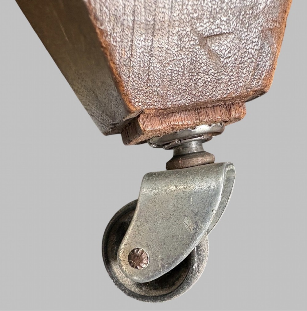 A traditional English wingback armchair upholstered in a teal and tan plaid Shetland wool pattern with turned front legs on brass castors. View VIII