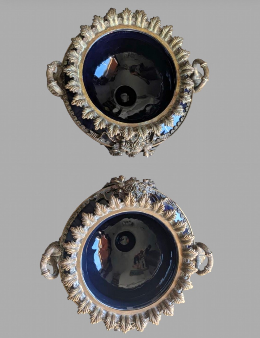 A pair of deep cobalt blue glazed ceramic urn-shaped jardinieres adorned with ornate gilt bronze mounts, floral swags, and decorative handles, set on footed bases. View II